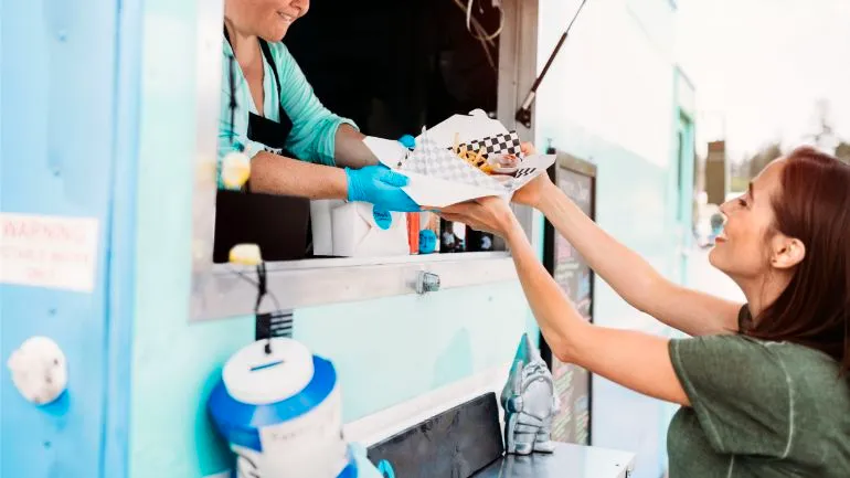 A women receiving her order at a food truck