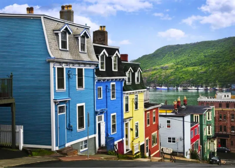 a picture of a street in downtown st johns with a row of colorful houses