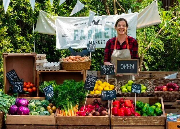 A women and her fruit/vegetable stall at a farmers market